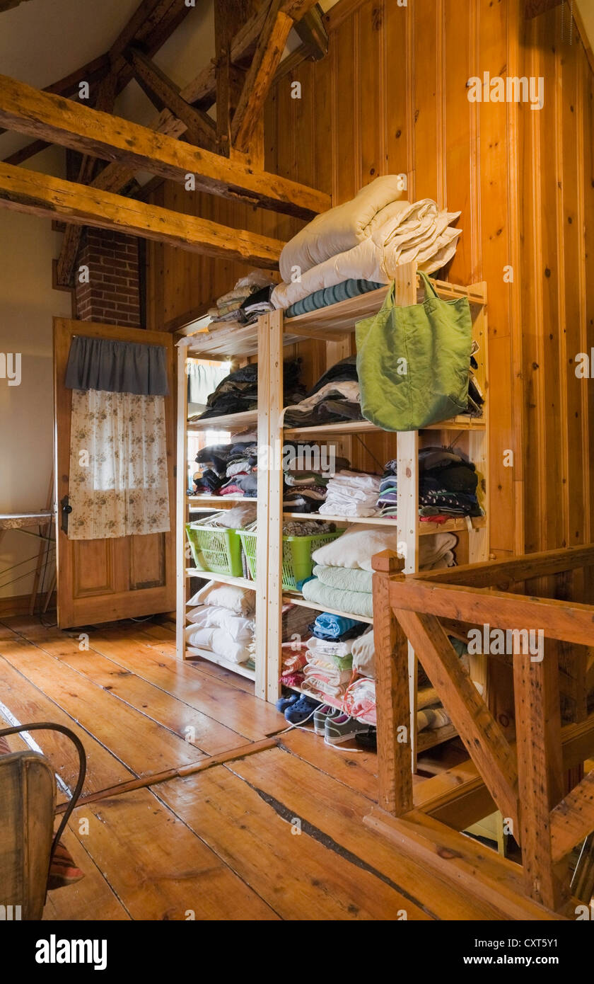 Les vêtements stockés sur une étagère ouverte dans la chambre à l'étage d'une ancienne résidence de style cottage Canadiana log home, vers 1825, Banque D'Images