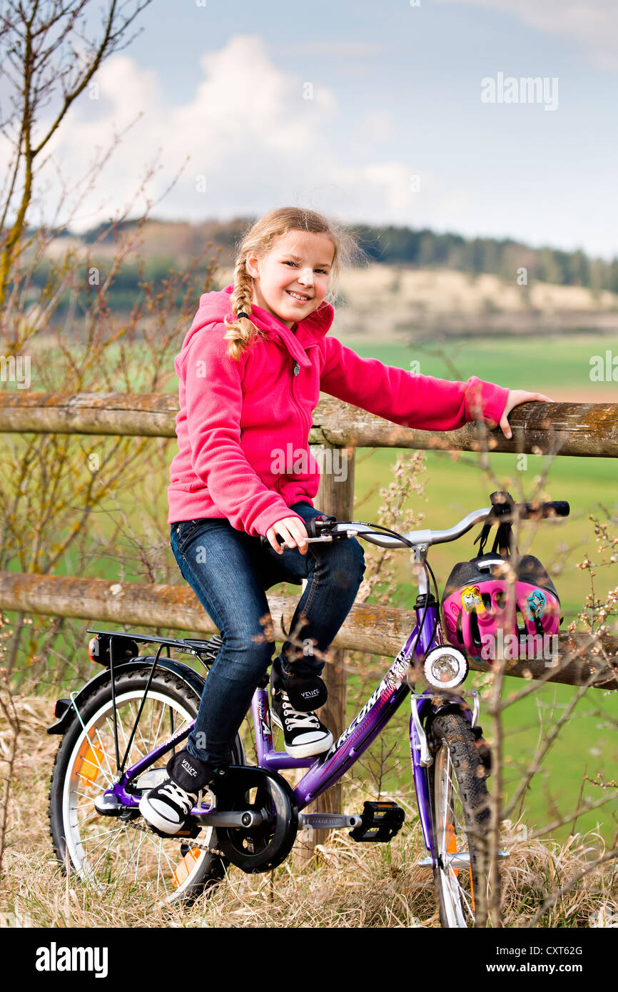 Fille avec son vélo en face du paysage rural Banque D'Images