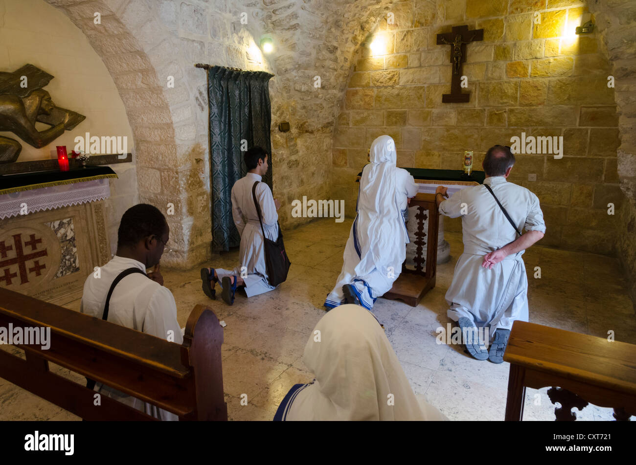 Des religieuses et des prêtres de genou et prier à la chapelle de la station V, Chemin de la Croix. Vieille ville de Jérusalem. Israël. Banque D'Images