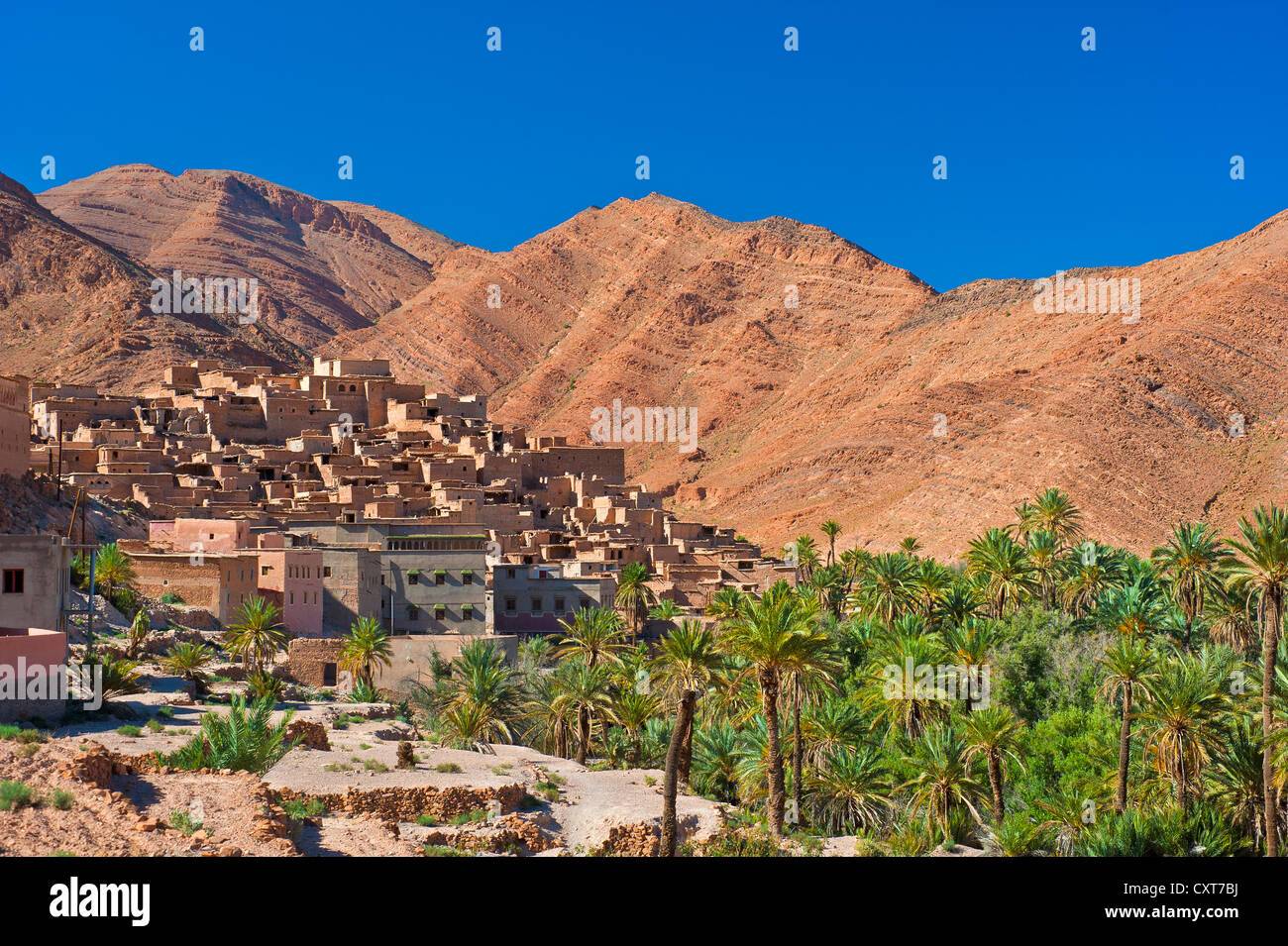 Petit village d'argile et d'une palmeraie, en face de la montagne rouge paysage dans la vallée Ait Mansour, Anti-Atlas Banque D'Images