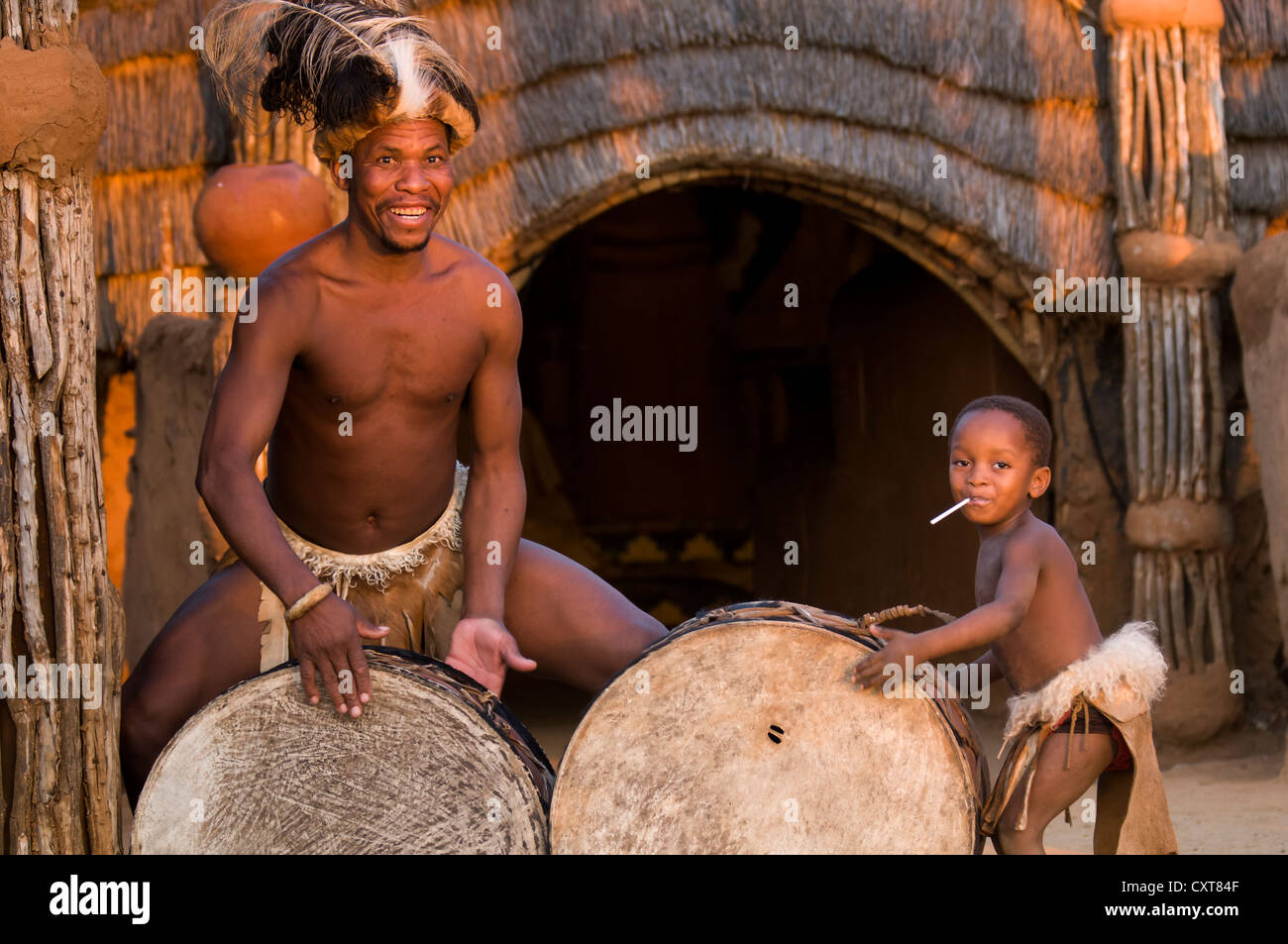 Zulu homme en costume traditionnel à jouer de la batterie, l'ensemble de film Shakazulu, Shakaland, KwaZulu-Natal, Afrique du Sud, l'Afrique Banque D'Images