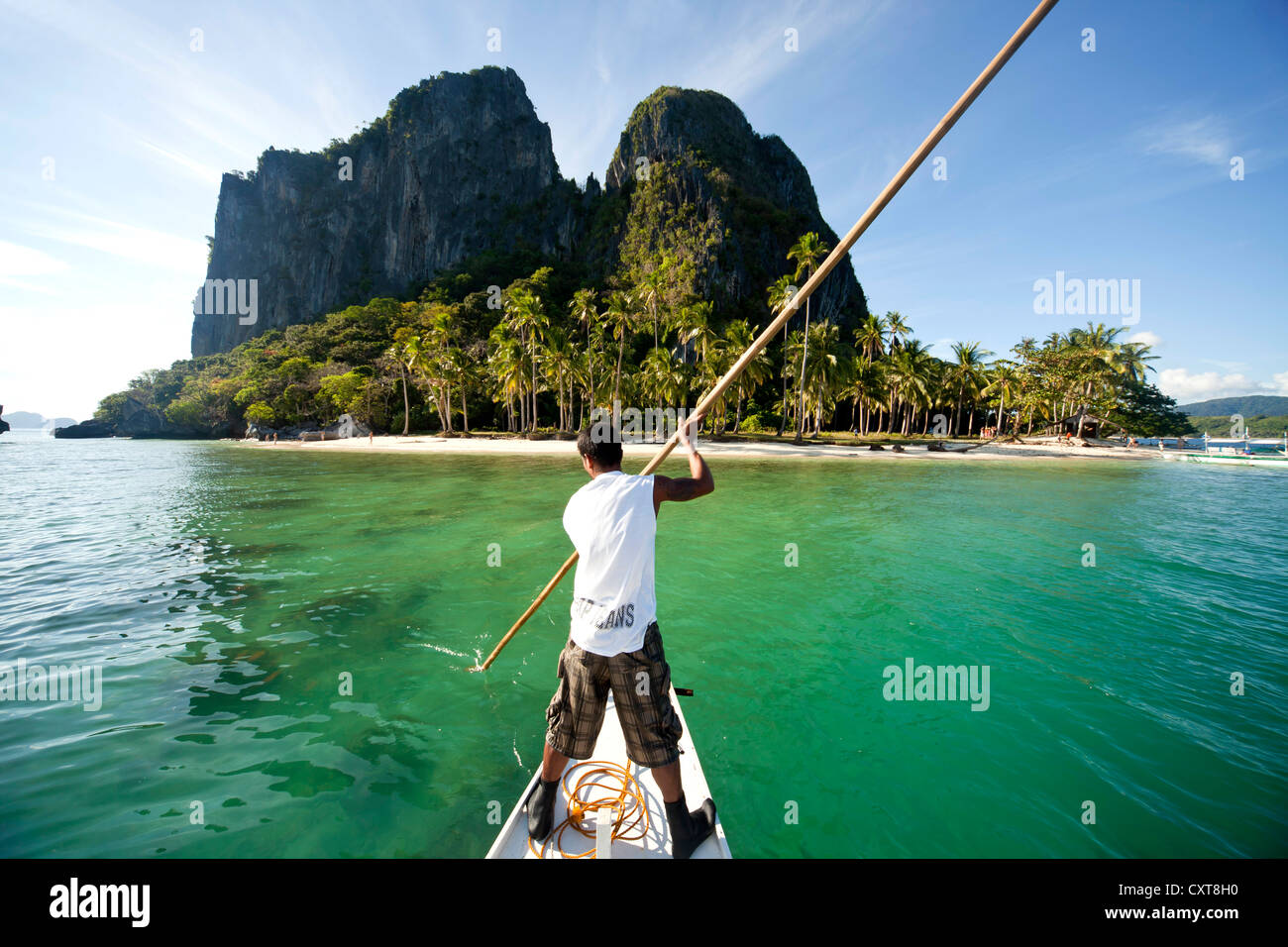 Boatsman dans une approche traditionnelle de l'île en bateau outrigger Inabuyutan, Bacuit Archipelago, El Nido, Palawan, Philippines, Asie Banque D'Images