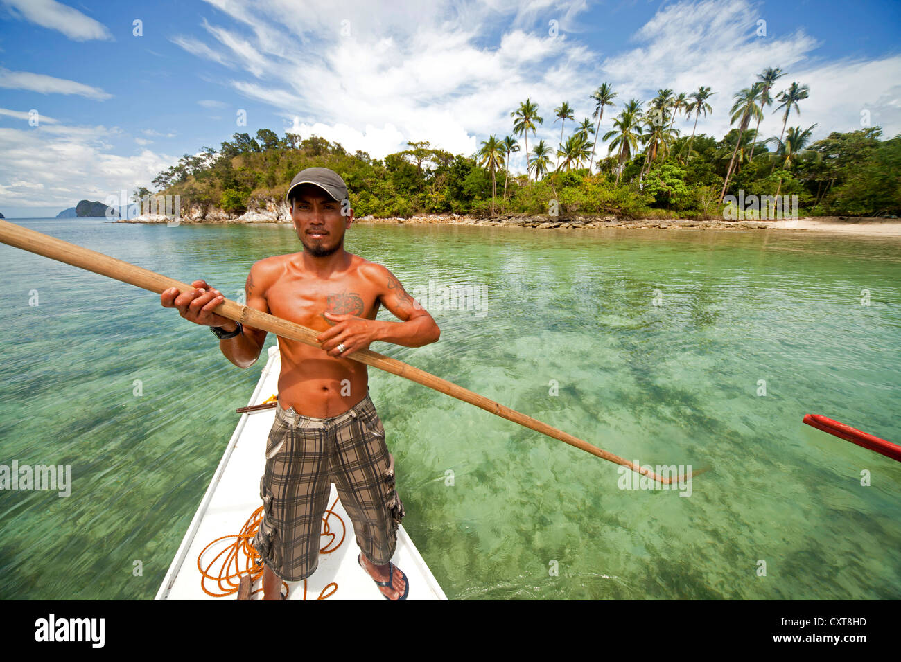 Boatsman dans un outrigger bateau sur le départ de l'île Snake, Bacuit Archipelago, El Nido, Palawan, Philippines Banque D'Images