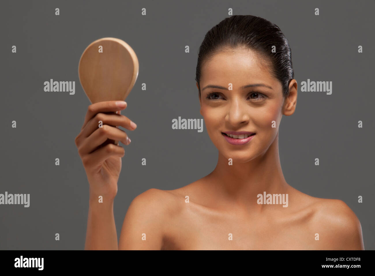 Close-up of beautiful young woman looking at hand mirror Banque D'Images