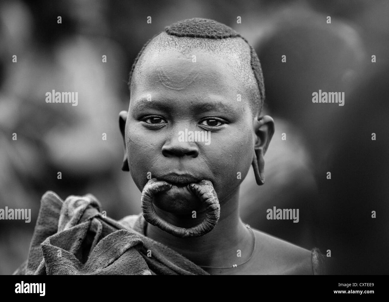 Fille avec une tribu Suri lèvre élargie lors d'une cérémonie organisée par le gouvernement, Kibish, vallée de l'Omo, Ethiopie Banque D'Images