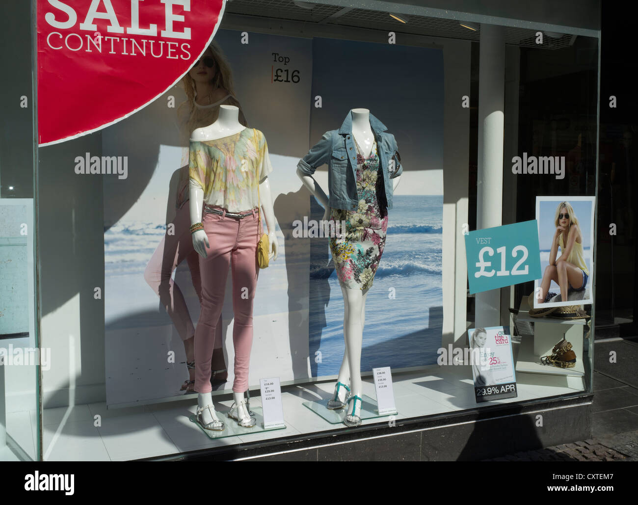 dh shop vitrine SHOPPING UK solde vitrine jeunes femmes mode les affiches extérieures des vêtements habillés affichent les magasins de grande-bretagne en magasin Banque D'Images