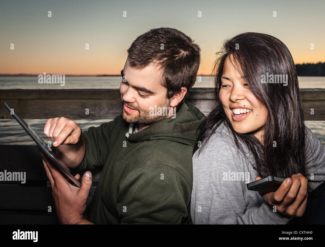 Couple using tablet computer outdoors Banque D'Images