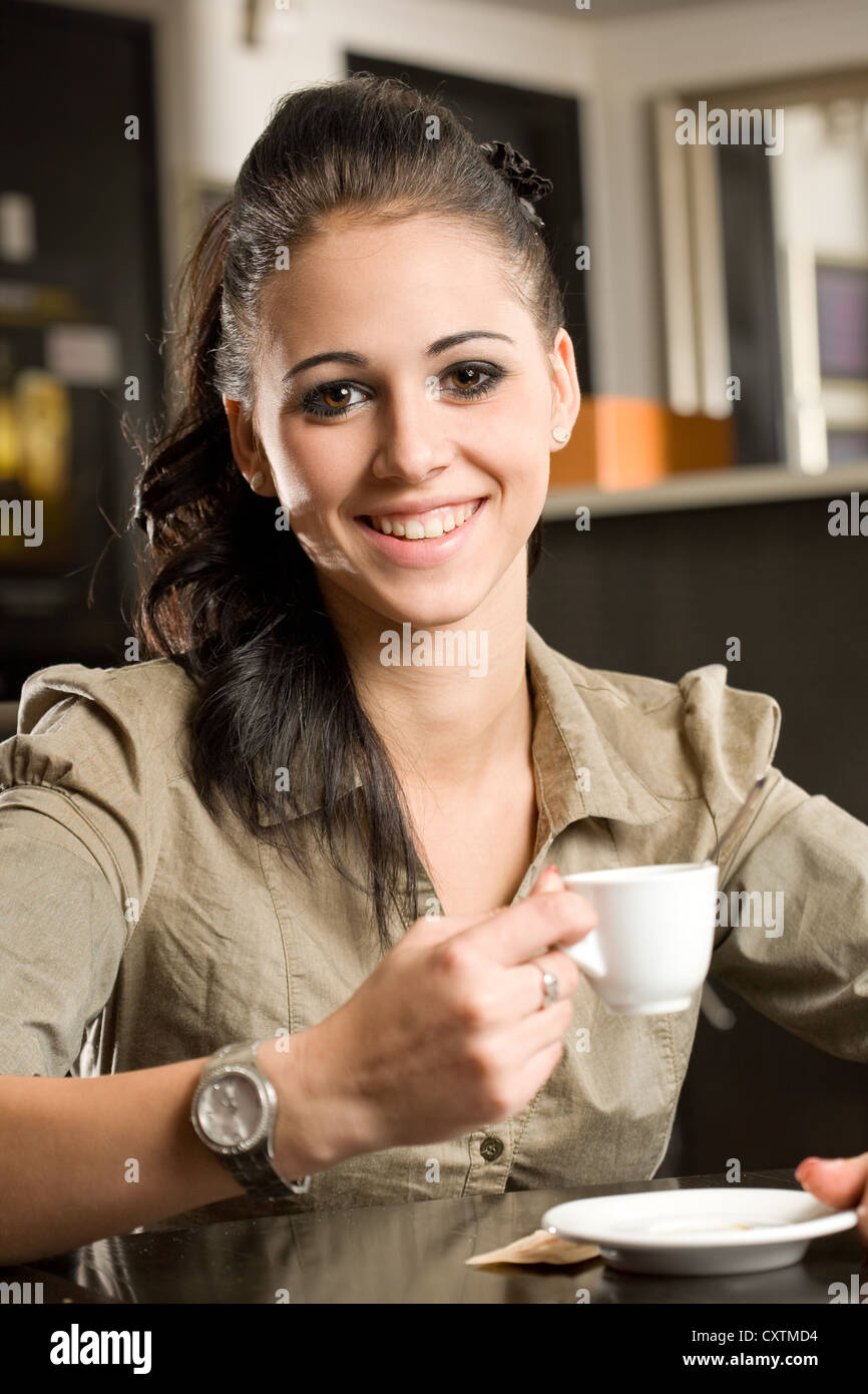 Portrait d'une belle jeune femme brune à la mode d'avoir du café. Banque D'Images