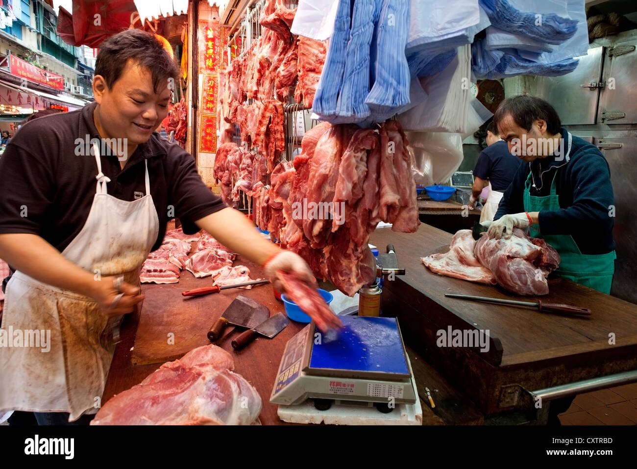 Deux bouchers préparent des découpes de viande pendant une période creuse à  leur boucherie dans le Marché Central de Hong Kong Photo Stock - Alamy