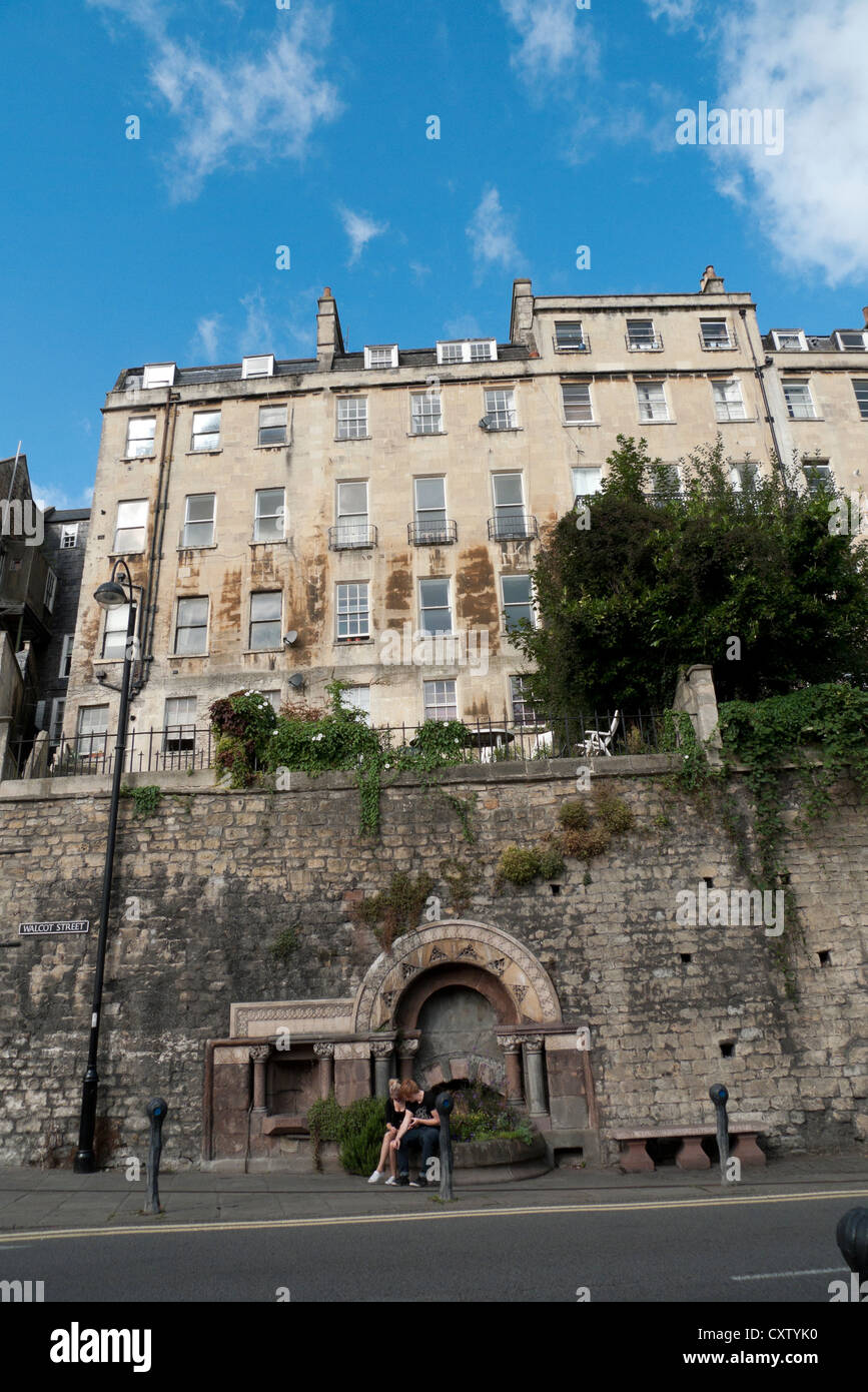 Un couple assis par une fontaine historique sur London Road ci-dessous Walcot parade dans la ville de Bath Spa, Avon, Somerset, Angleterre Royaume-uni Banque D'Images