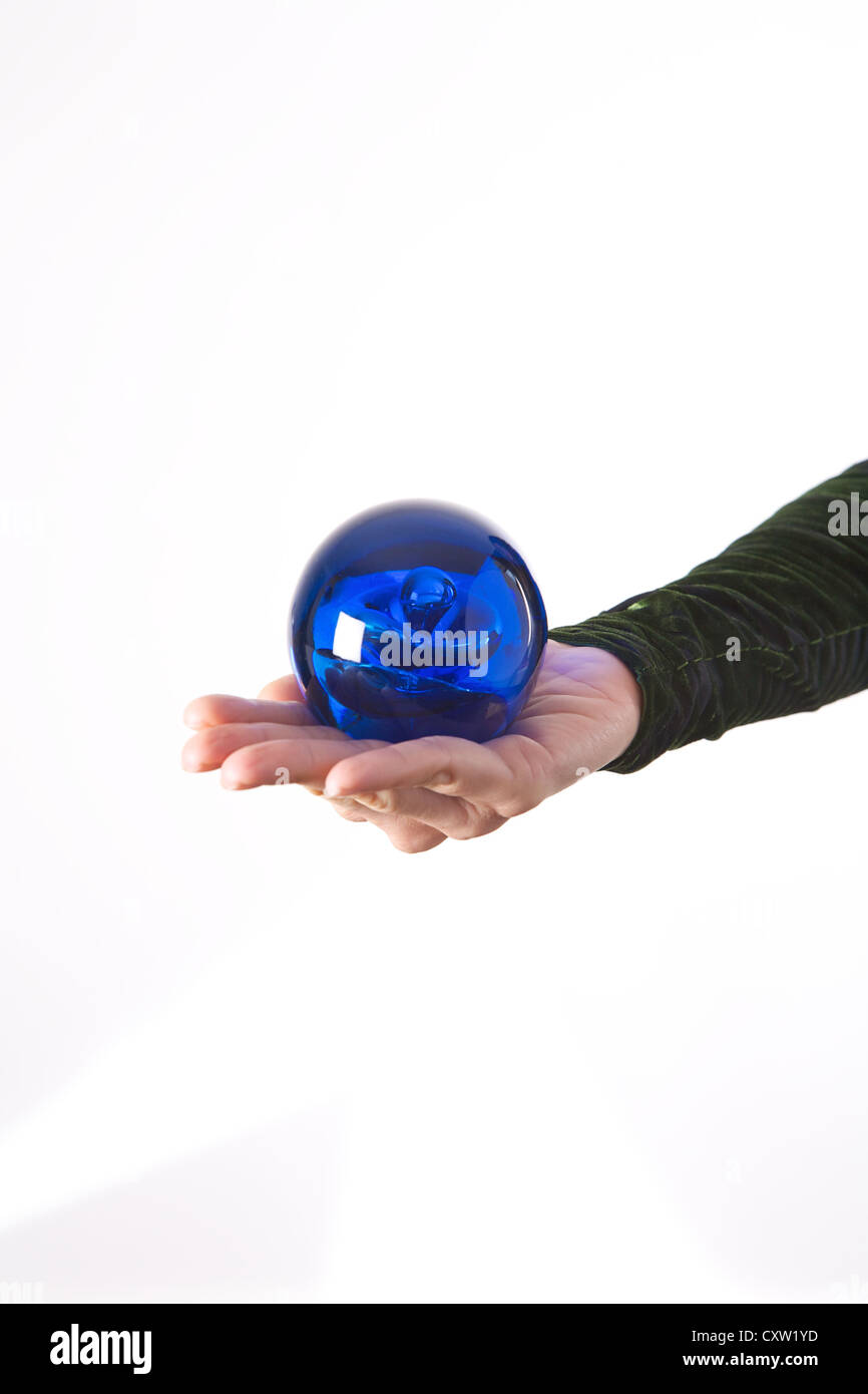 Détail main Femme avec une boule bleue sur sa paume Banque D'Images