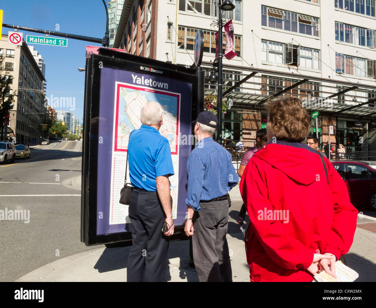 La lecture de la carte d'Information De touristes matures, Yaletown, Vancouver, CA Banque D'Images