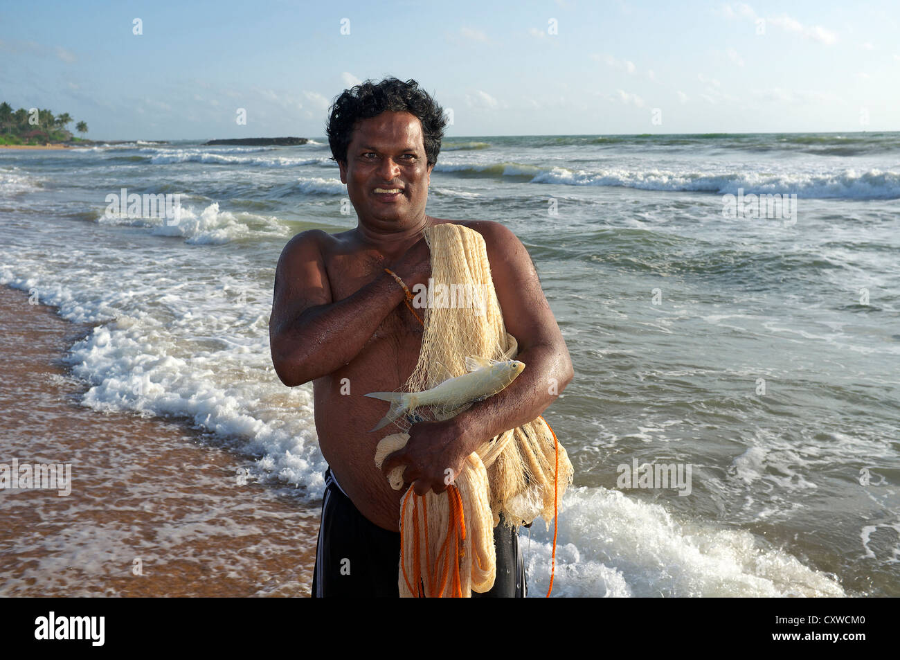 Le pêcheur local à l'aide d'un jet net pour attraper des poissons dans l'Océan Indien au large de la côte à Waikkal, Sri Lanka Banque D'Images