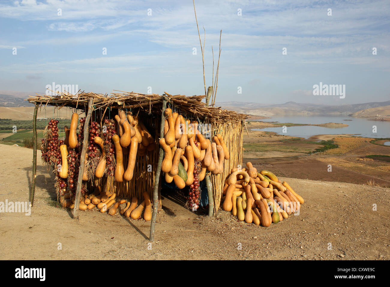 Écrou de beurre les oignons et la courge en vente sur un étal en bordure d'un lac et les montagnes du Rif au Maroc dans le backgrond Banque D'Images