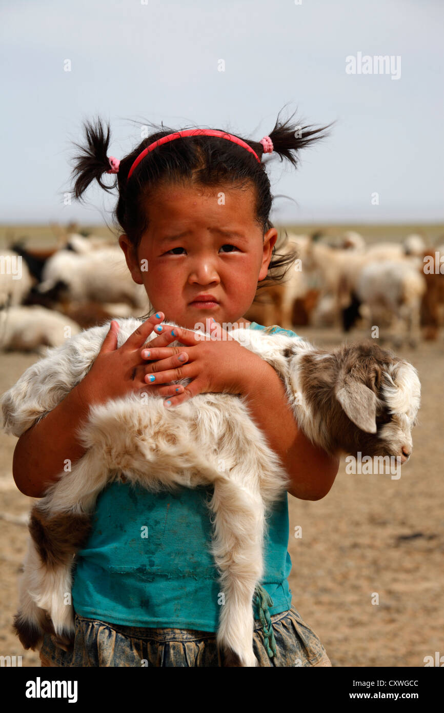 Portrait de petite fille mongole tenant un agneau dans ses bras, la Mongolie Banque D'Images