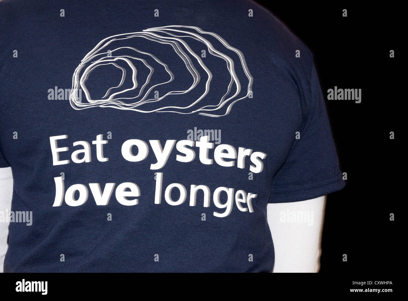 Un serveur à l'Oyster Festival à Falmouth, Cornwall, uk, portant un t-shirt avec un slogan imprimé sur elle d'huîtres Banque D'Images