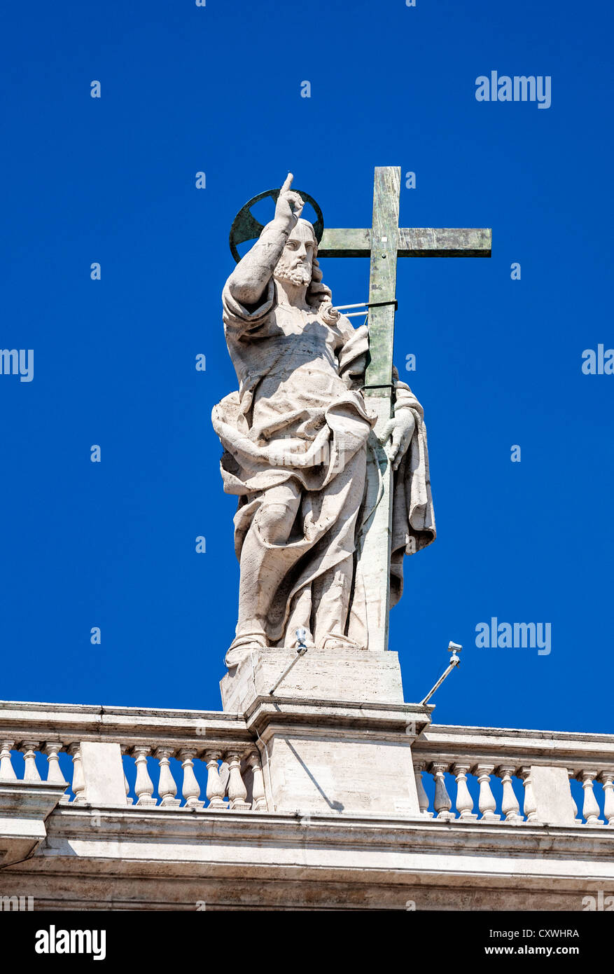 Statue de Jésus Christ portant une croix au sommet de la Basilique Saint-Pierre, Vatican, Rome, Italie. Banque D'Images