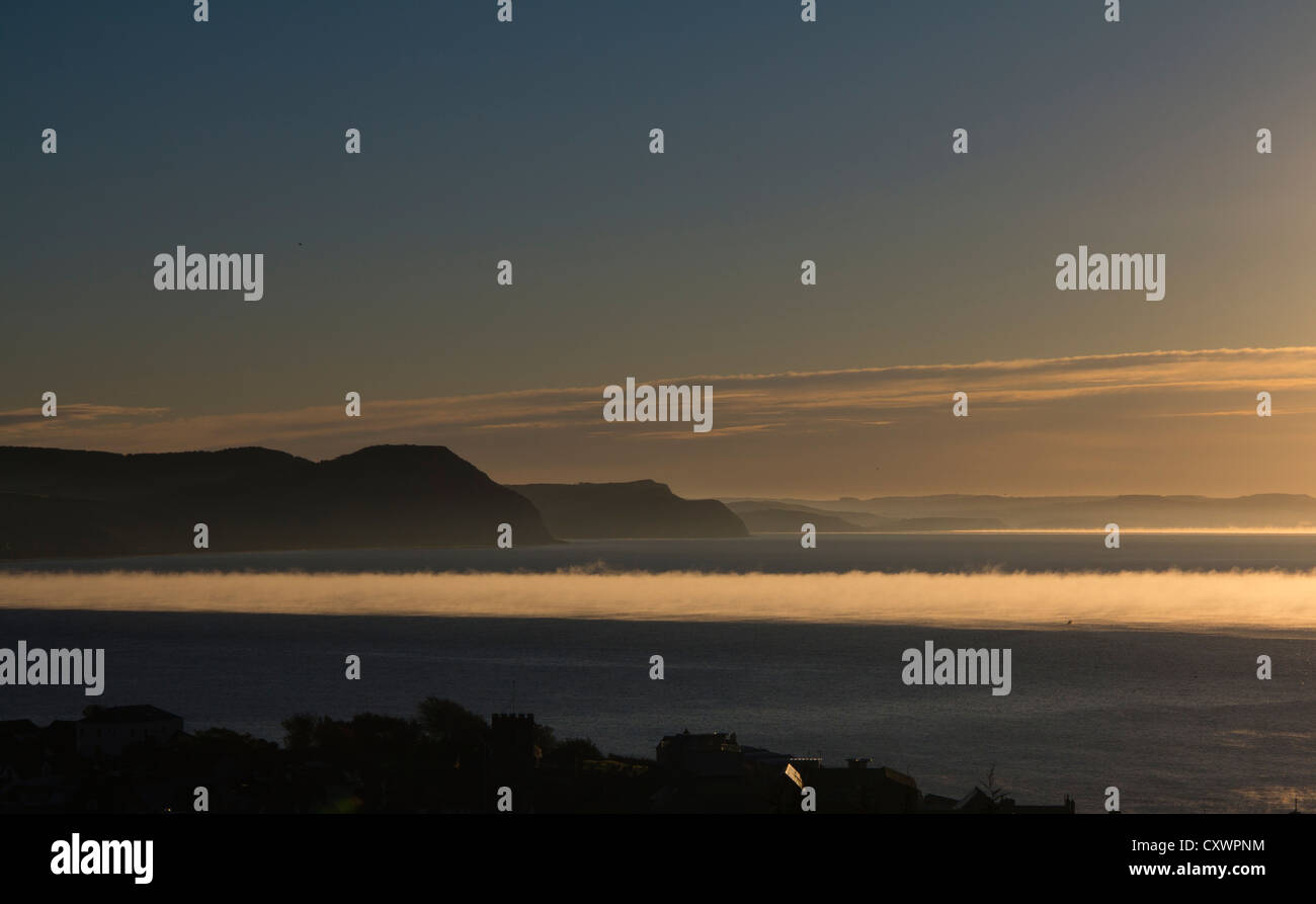Brume sur la mer au lever du soleil, la baie de Lyme, à la recherche pour Golden Cap Banque D'Images