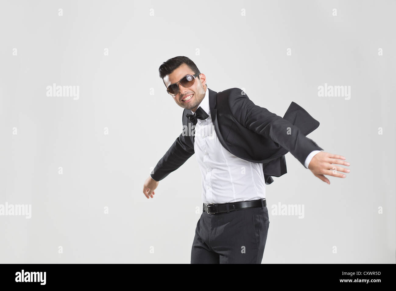 Smiling man in tuxedo dancing Banque D'Images