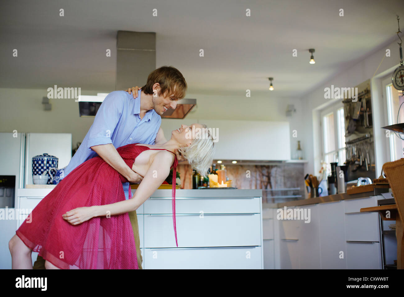 Couple dancing together in kitchen Banque D'Images