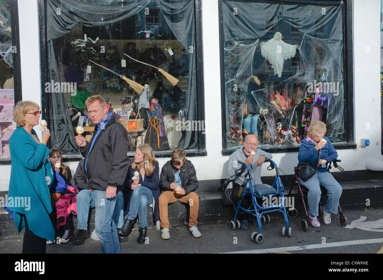 Les gens de manger des glaces dans la région de Falmouth, Cornwall, UK au cours de temps exceptionnellement doux en octobre. Décorations Halloween show Banque D'Images