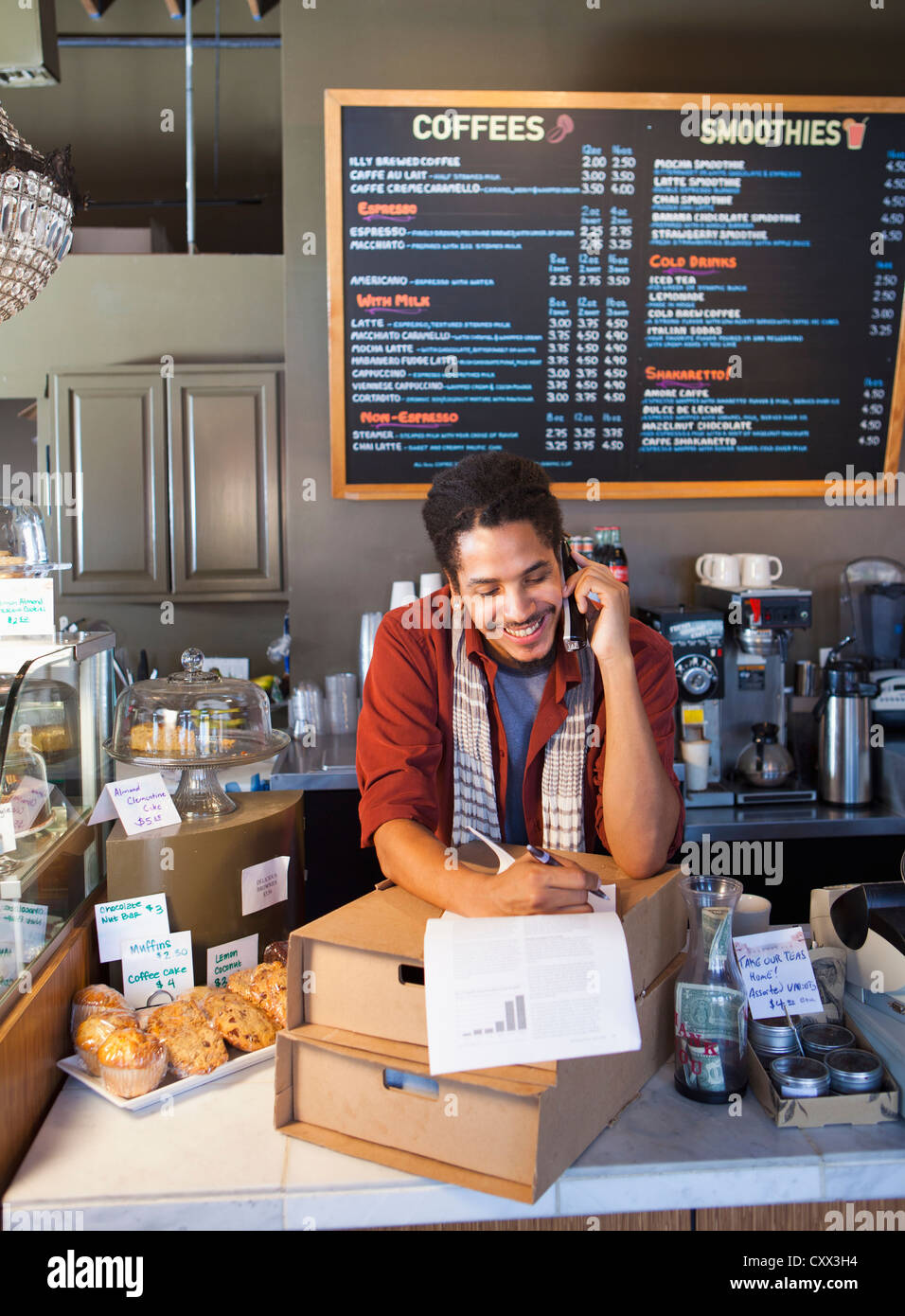 Mixed Race man working in coffee shop Banque D'Images