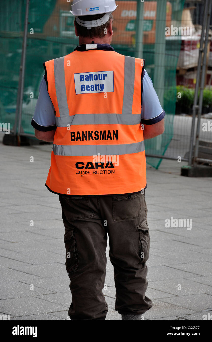 Espérons que l'hôpital, Salford. Construction Worker in hi vis vest l'exercice de fonctions, pontier-élingueur surveiller le site. Banque D'Images