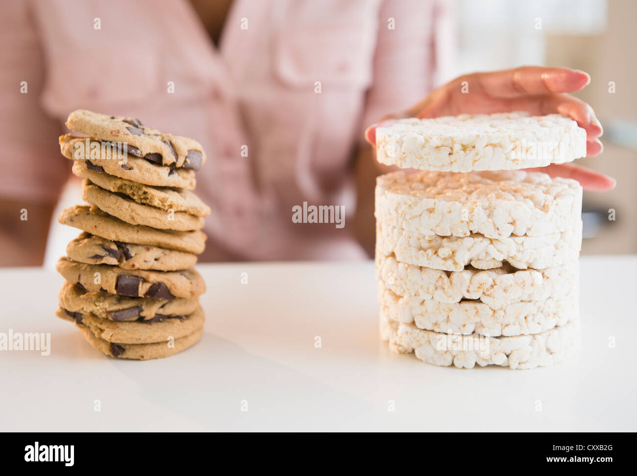 Cape Verdean woman stacking biscuits et gâteaux de riz Banque D'Images