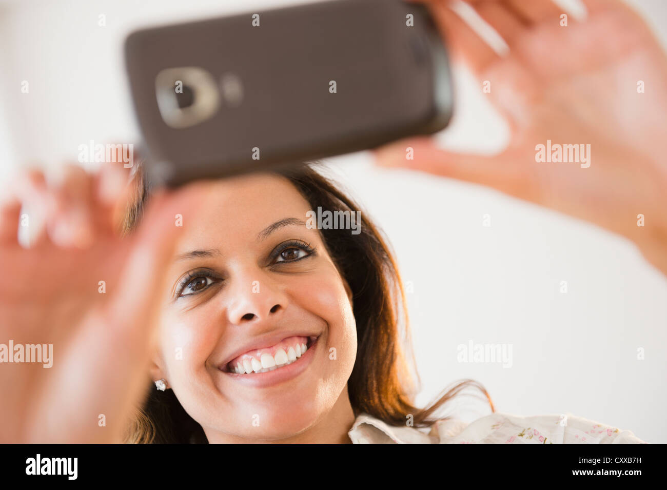Cape Verdean woman taking photograph with cell phone Banque D'Images