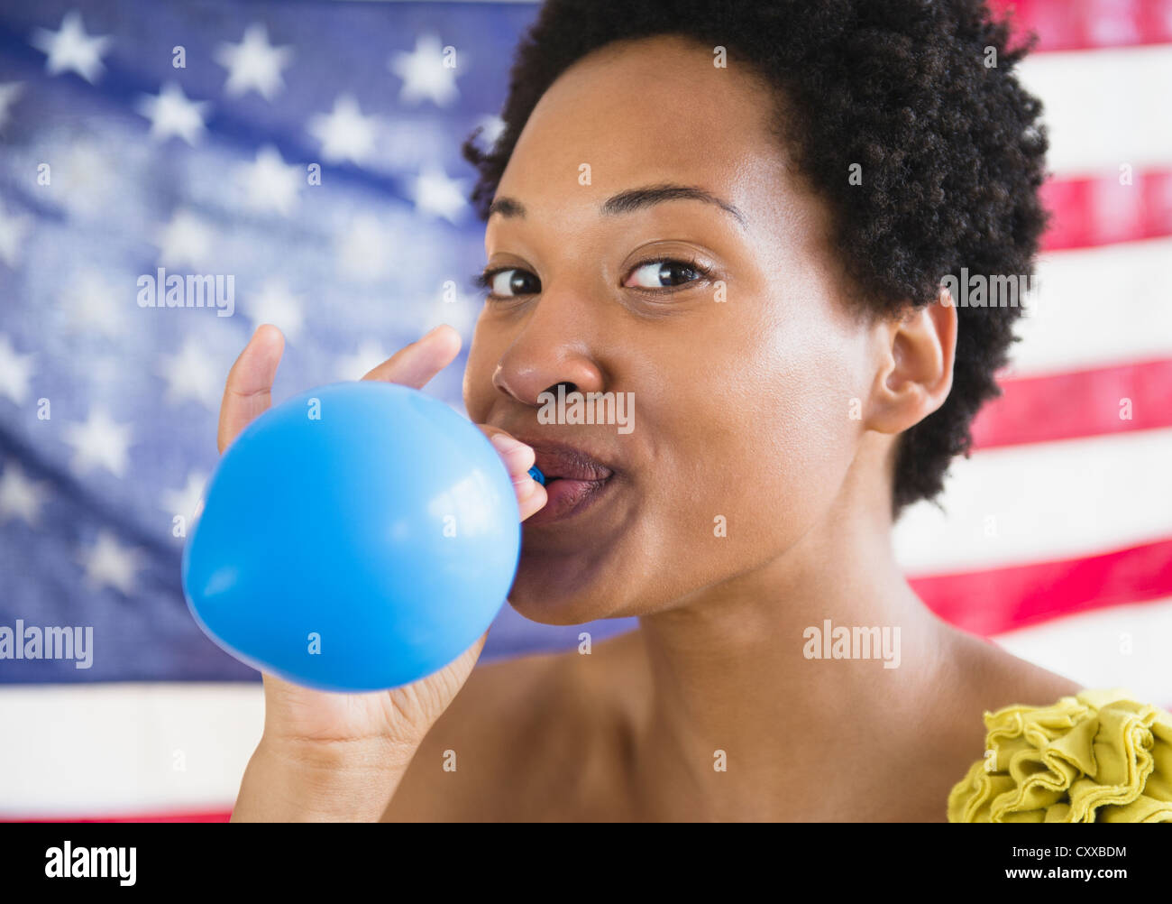 African American Woman Blowing up balloon bleu Banque D'Images