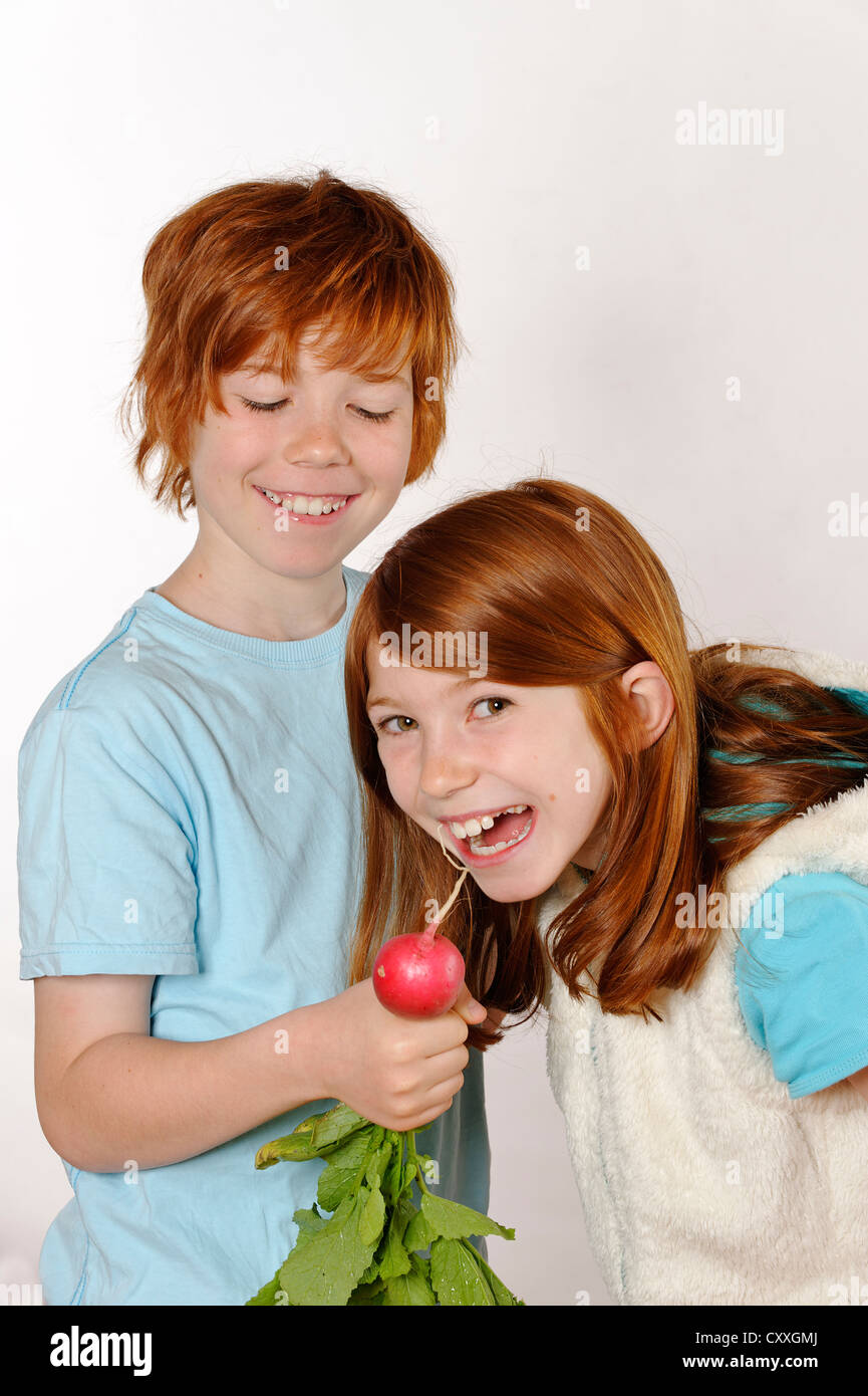 Fille et garçon Boy feeding un radis pour une fille Banque D'Images