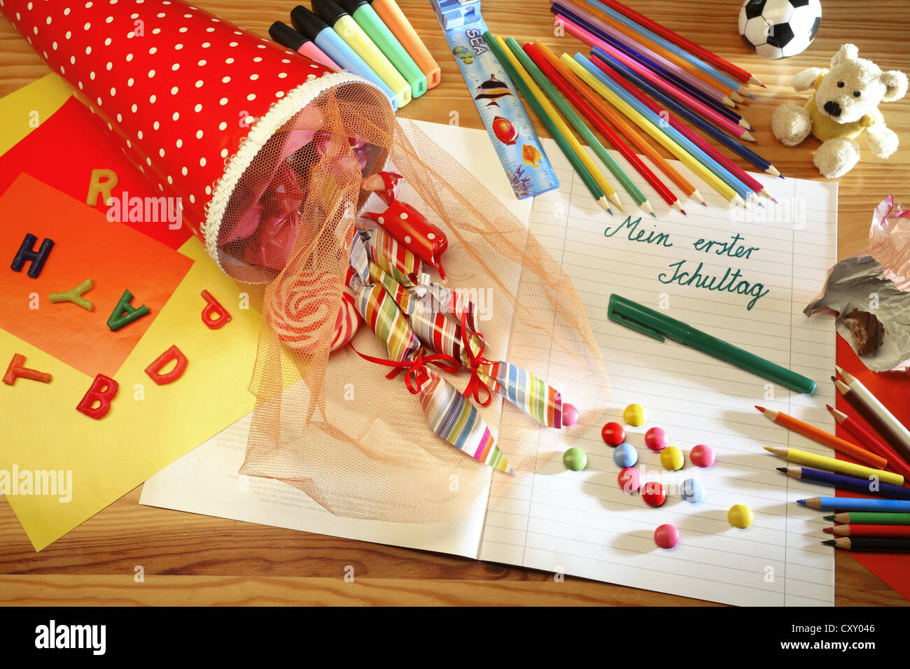 Schultuete ou cône scolaire rempli de cadeaux et de bonbons à côté de crayons de couleur et un ordinateur portable avec le titre Mein erster Banque D'Images