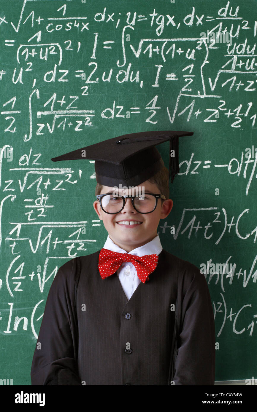 Écolier portant une graduation cap, des lunettes et un noeud papillon à  l'avant d'un tableau avec les équations mathématiques Photo Stock - Alamy