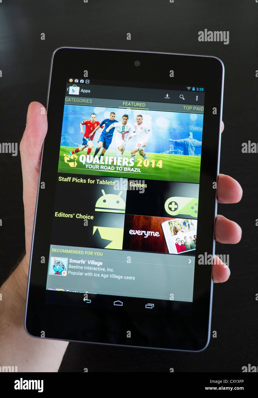 Man holding Google Nexus 7 Tablet sous Android système d'exploitation et de la navigation sur Play store pour les jeux Banque D'Images