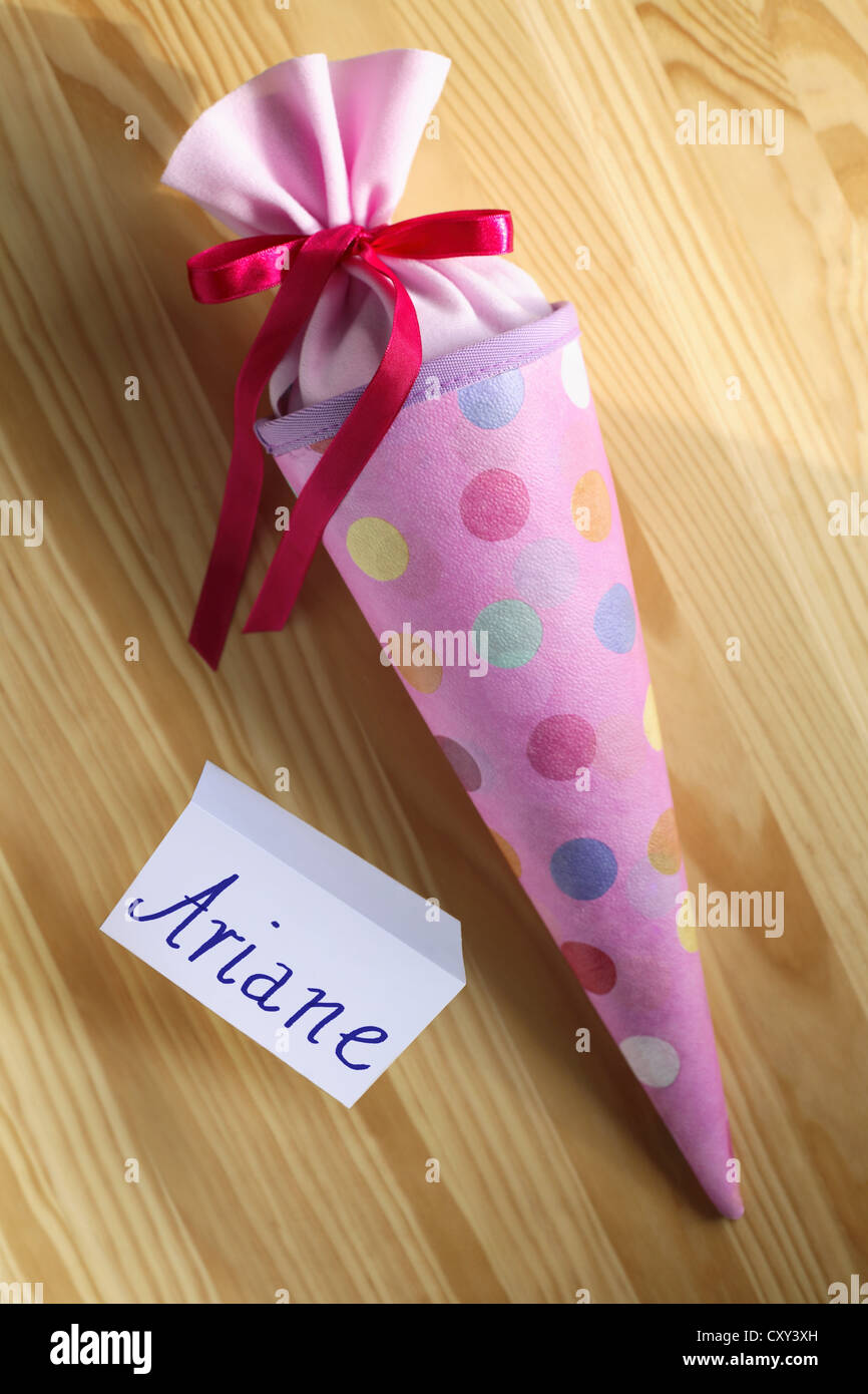 Schultuete ou cône rose école rempli de cadeaux et de bonbons à côté d'une étiquette-nom pour Ariane Banque D'Images