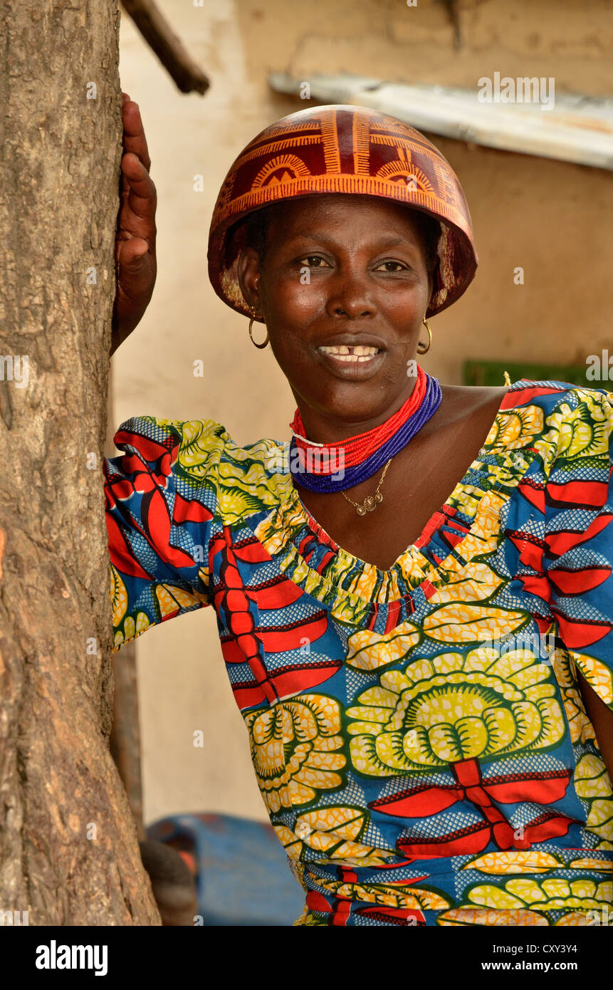 Femme portant la calebasse casque qui est typique pour la région et une robe colorée, village de tourou, Cameroun Banque D'Images