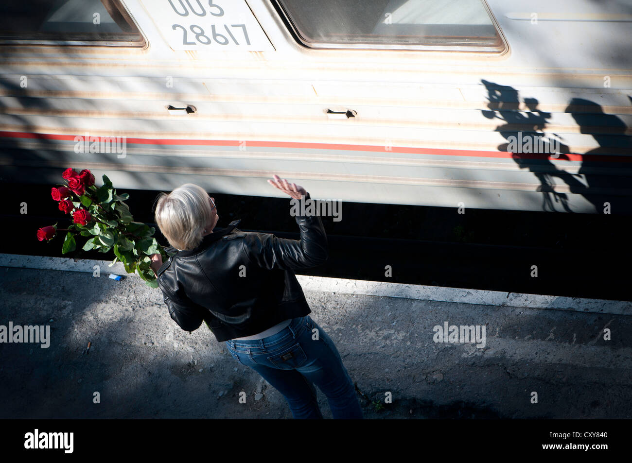 Une fille se félicite un ami à la gare Banque D'Images