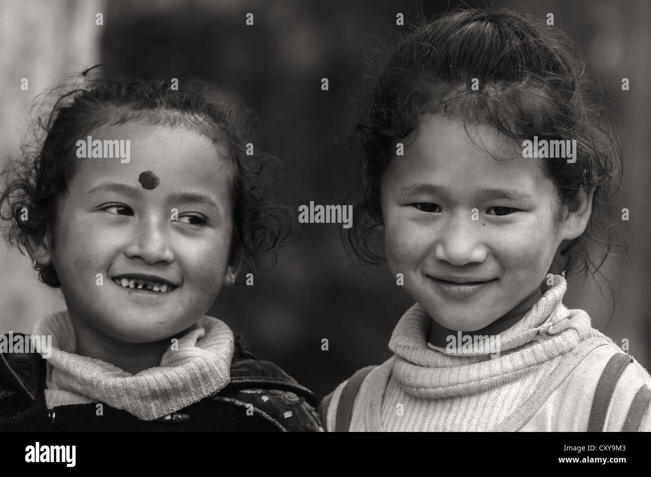 Photo en noir et blanc de deux soeurs, enfants, souriant, une face, portrait Banque D'Images