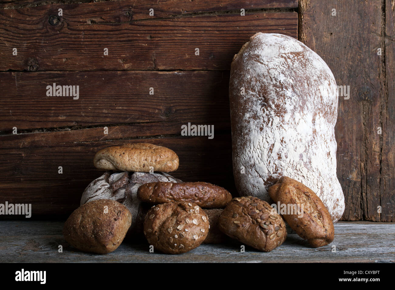 Miche de pain et petits pains sur une surface en bois rustique Banque D'Images