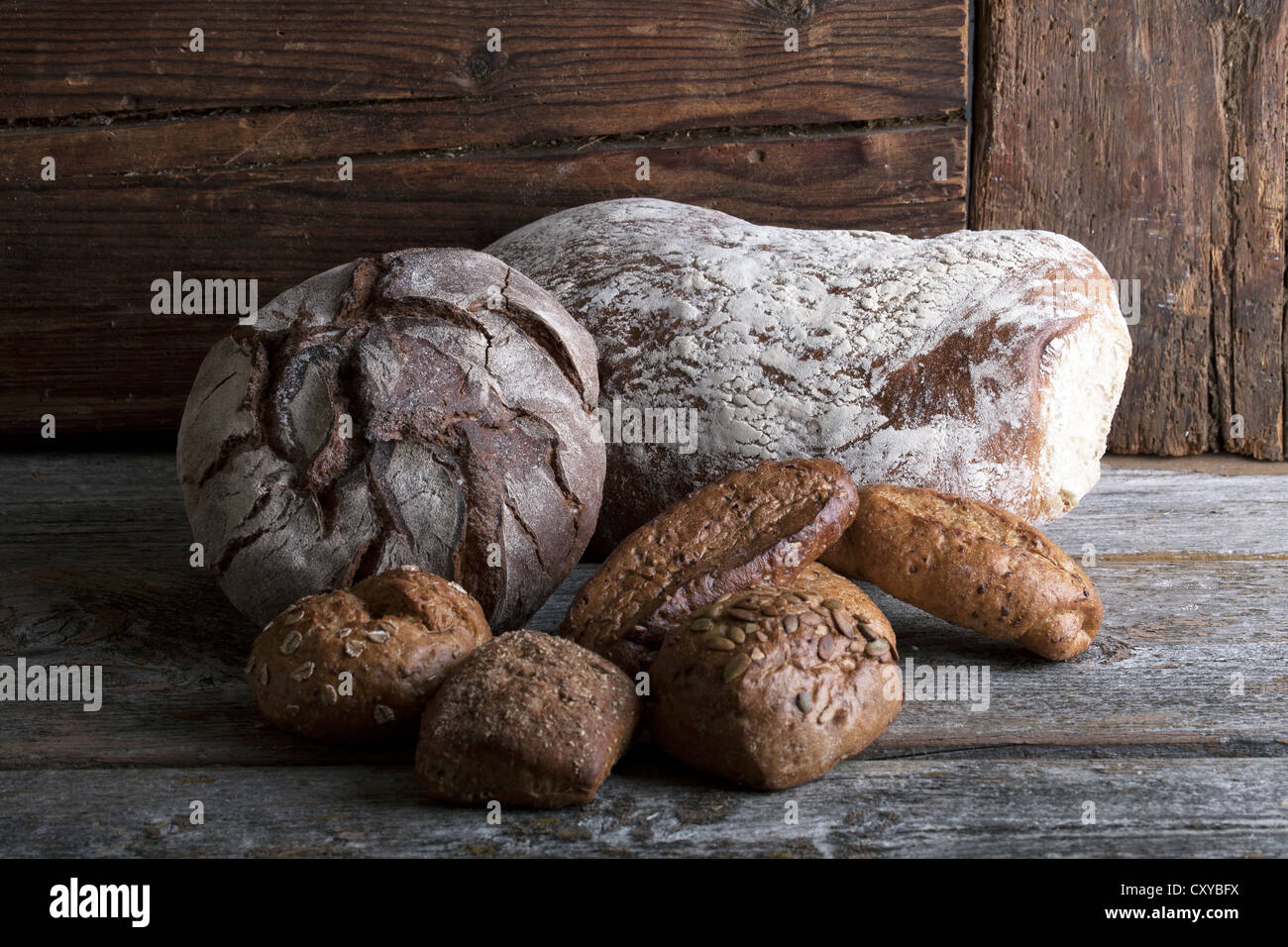 Pains et petits pains sur une surface en bois rustique Banque D'Images