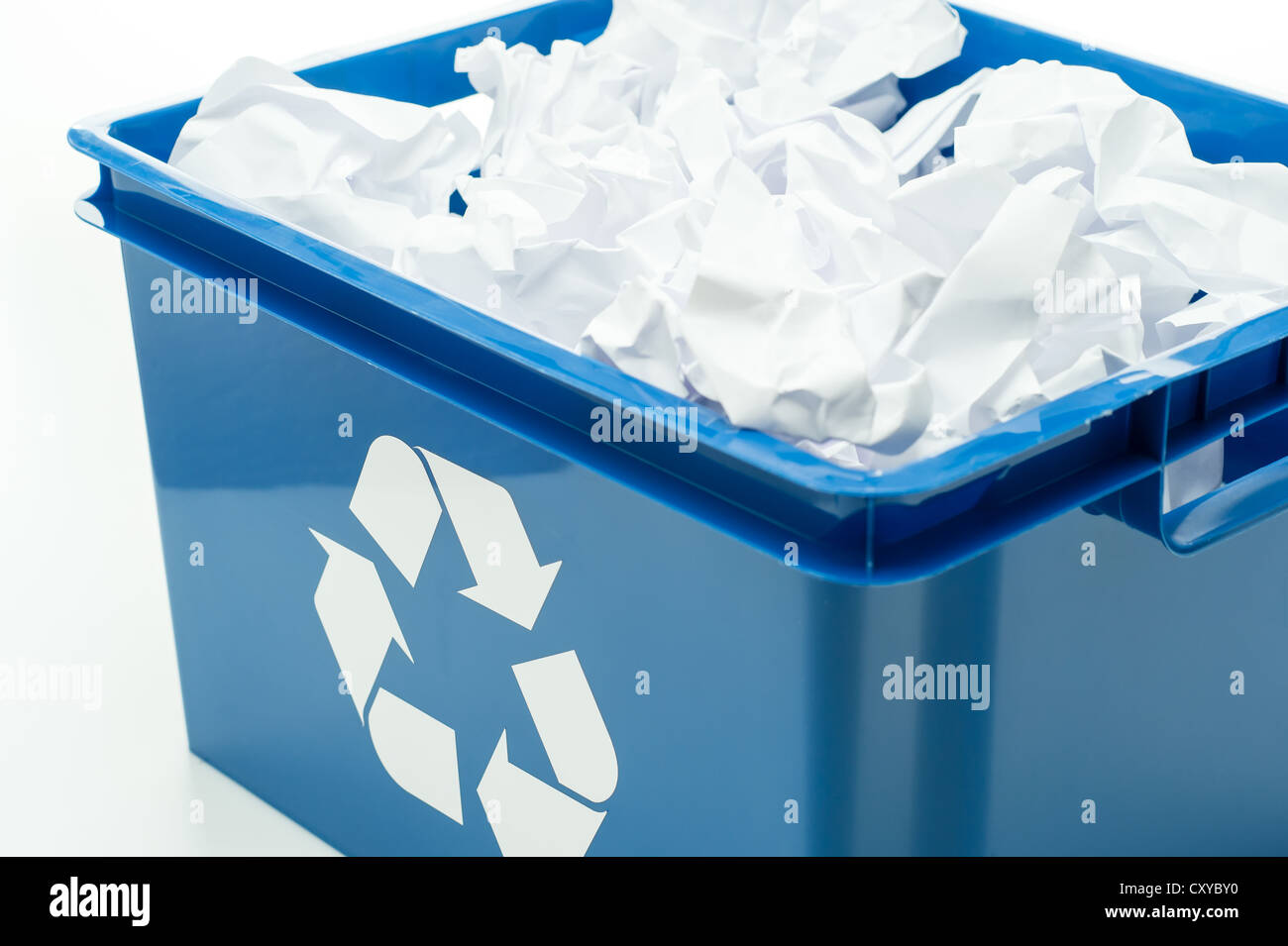 Bac de recyclage bleu fort avec des déchets de papier blanc sur Banque D'Images