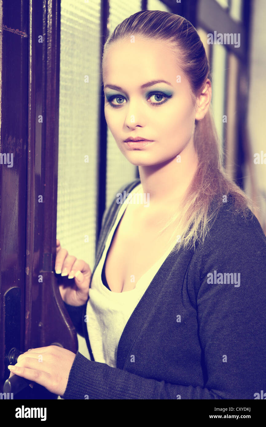 Portrait d'une femme debout devant une vieille porte Banque D'Images