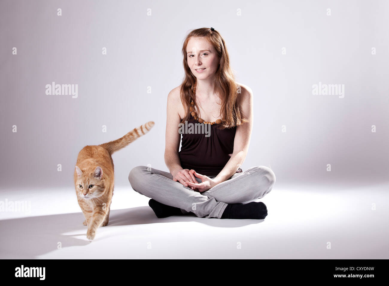 Red-haired woman et un chat roux Banque D'Images