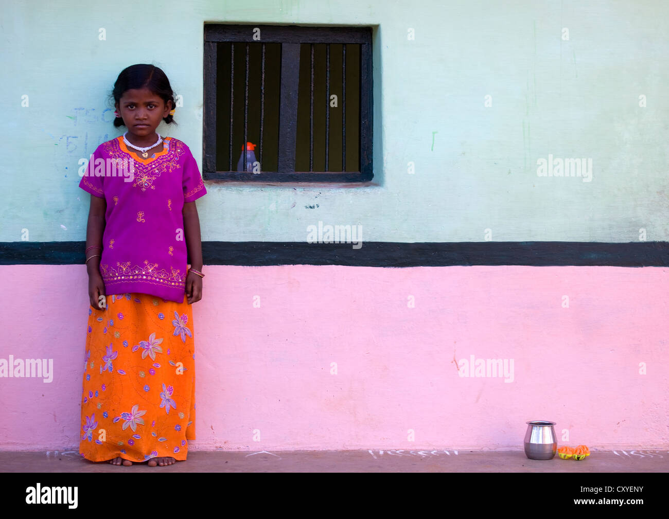 Petite fille avec un collier en face d'une maison traditionnelle dans le Tamil Nadu, Madurai, Inde Banque D'Images