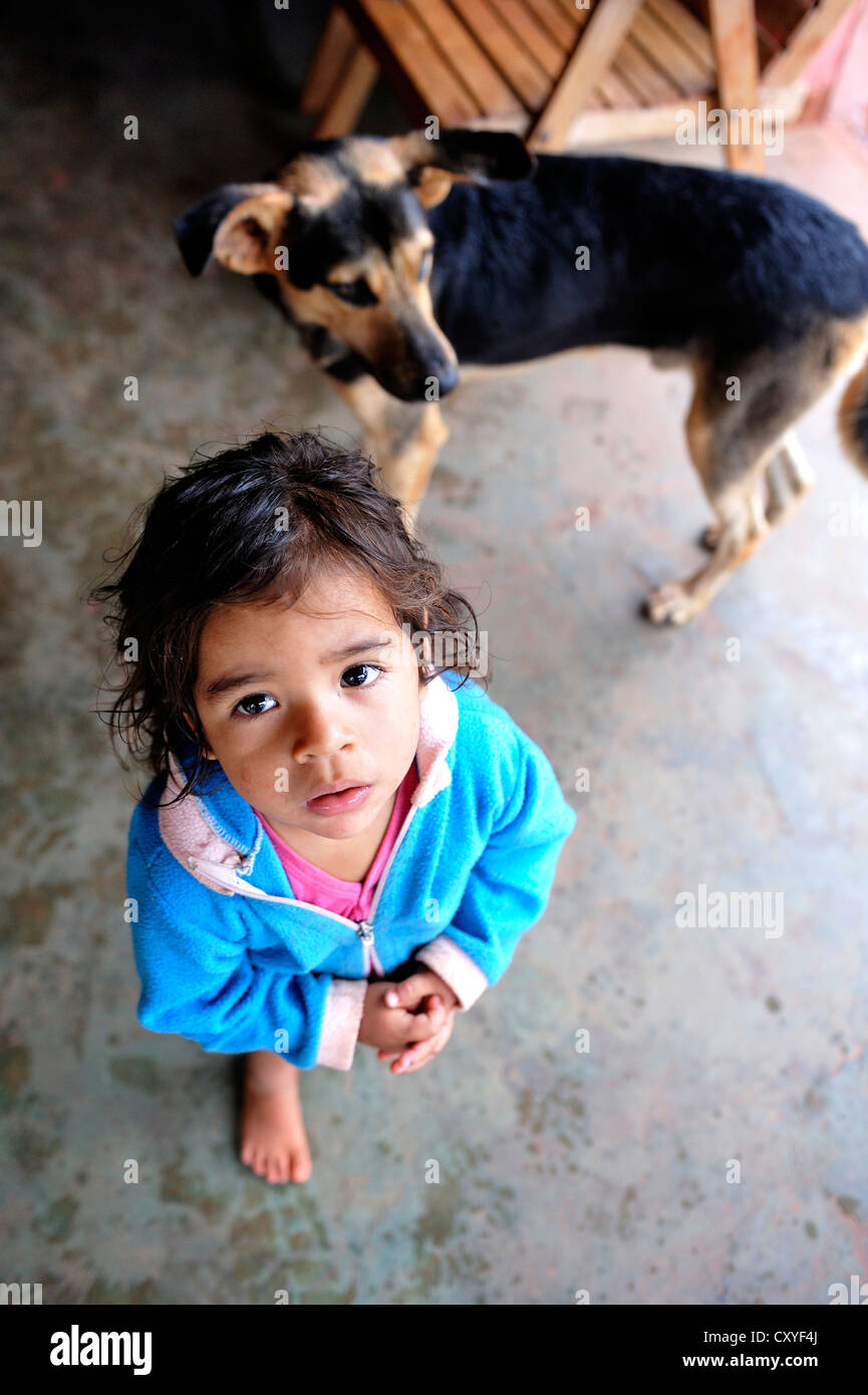 Little girl with a dog looking up, Comunidad Arroyito, Concepcion, Paraguay, Amérique du Sud Banque D'Images