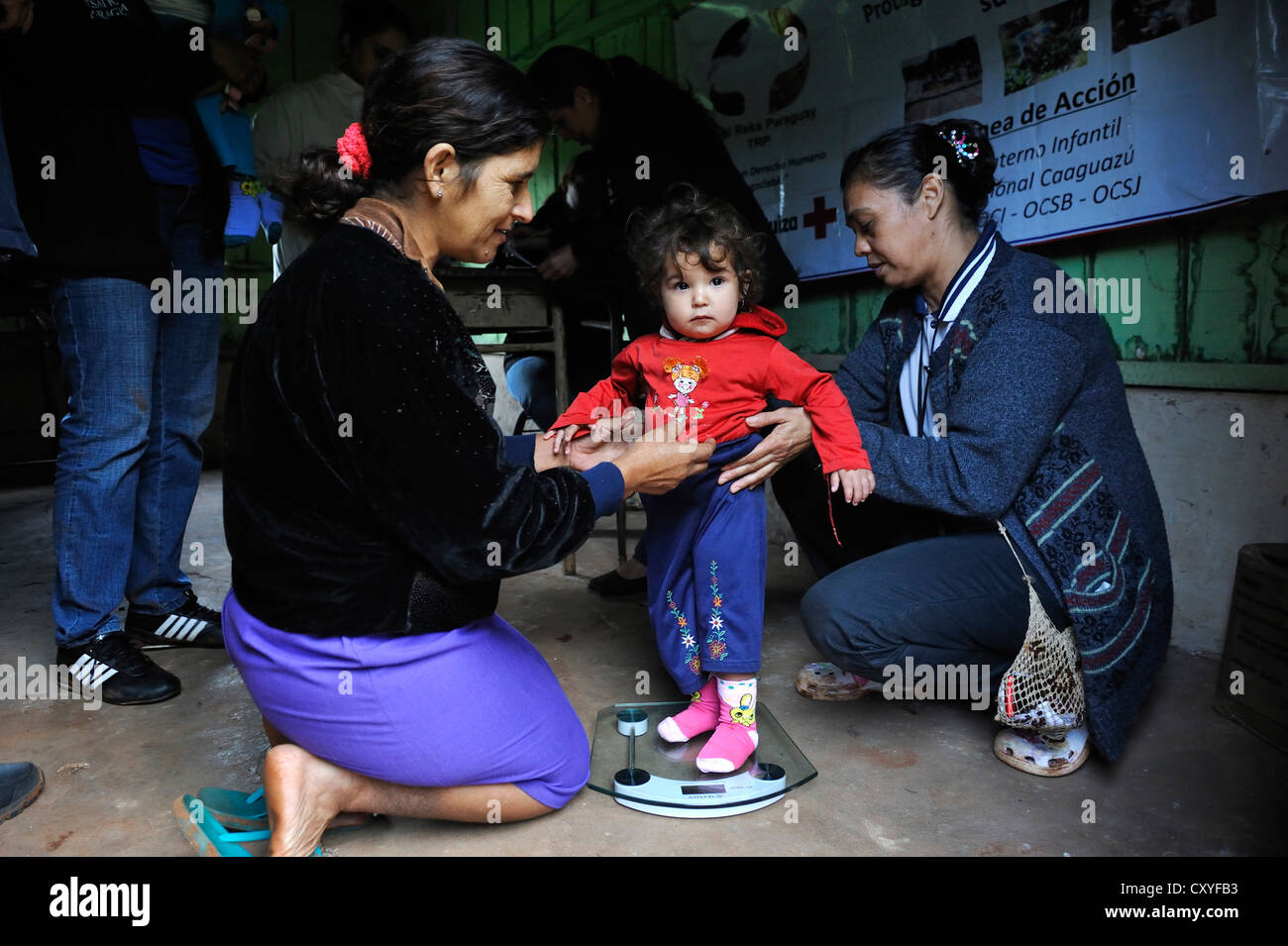 Une fille est pesé sur l'organisation de l'aide d'un pèse-personne, la prestation de services de santé et d'éducation pour les mères et les enfants en Banque D'Images