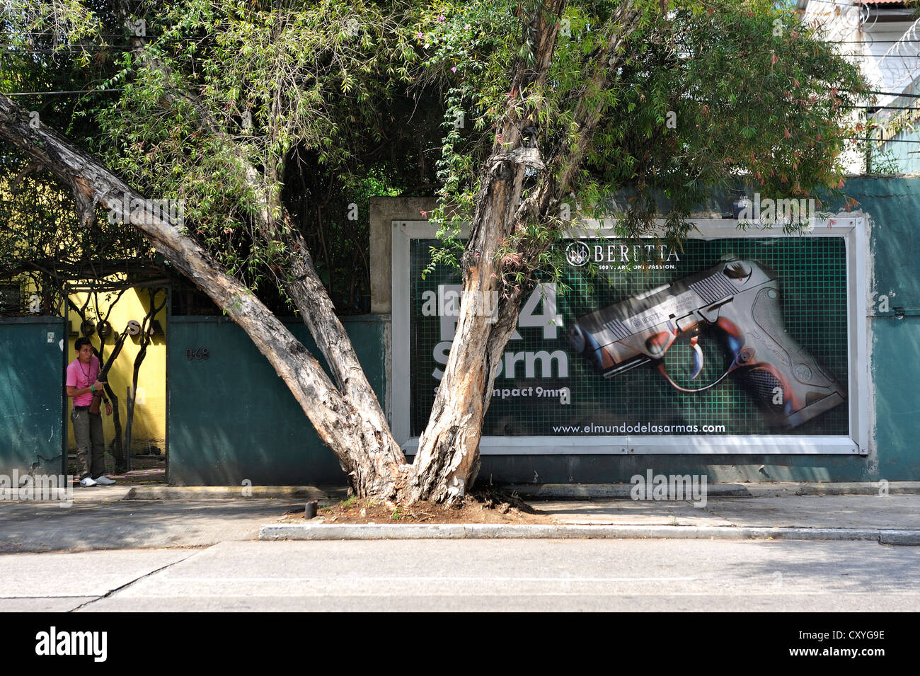 Panneaux publicitaires, publicité pour une arme à feu, sur la gauche un garde armé, debout devant une porte, la ville de Guatemala, Guatemala Banque D'Images