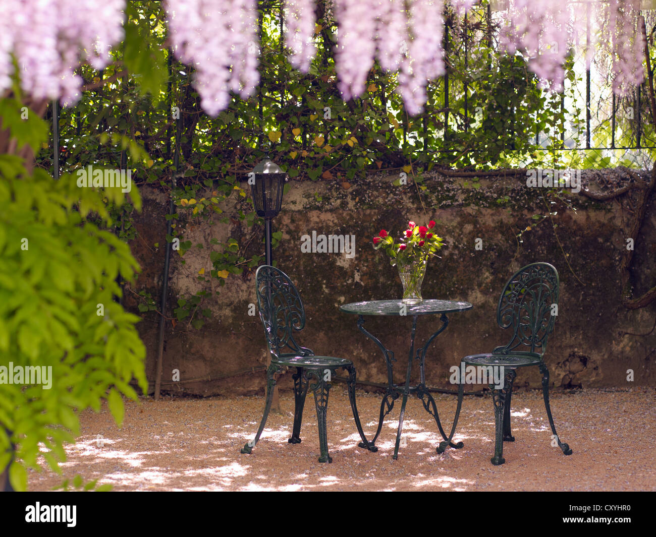 Still Life, ronde, en fonte antique table de jardin et deux chaises, dans une cour romantique Banque D'Images