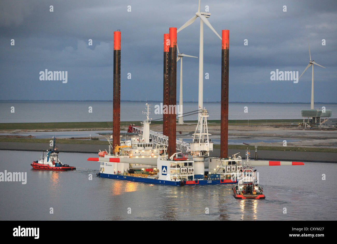 Navire utilisé pour la construction de fermes éoliennes offshore Eemshaven feuilles portant une tête de l'éolienne, guidé par des remorqueurs. Banque D'Images