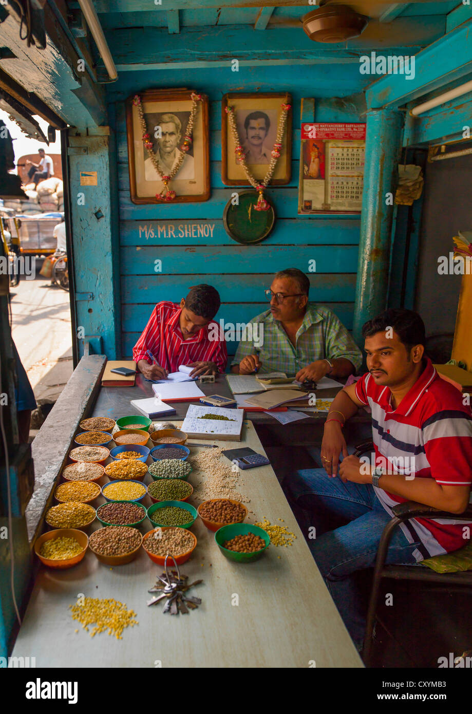 Ventes de céréales à travailler sur leurs affaires derrière leurs étals dans leur magasin, Cochin, Inde Banque D'Images